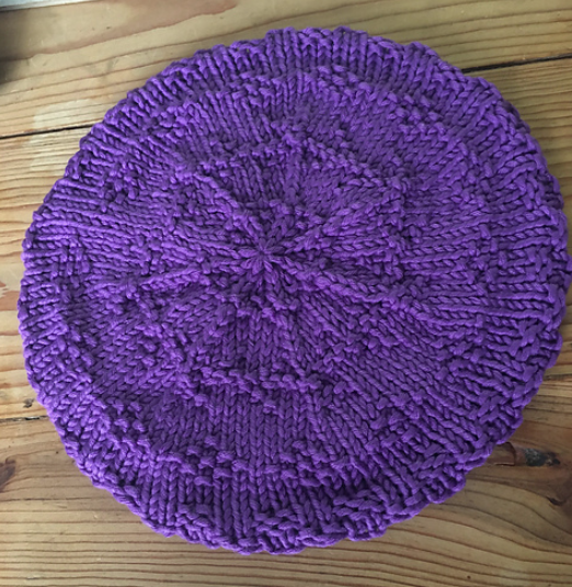 Purple beret flat on a table