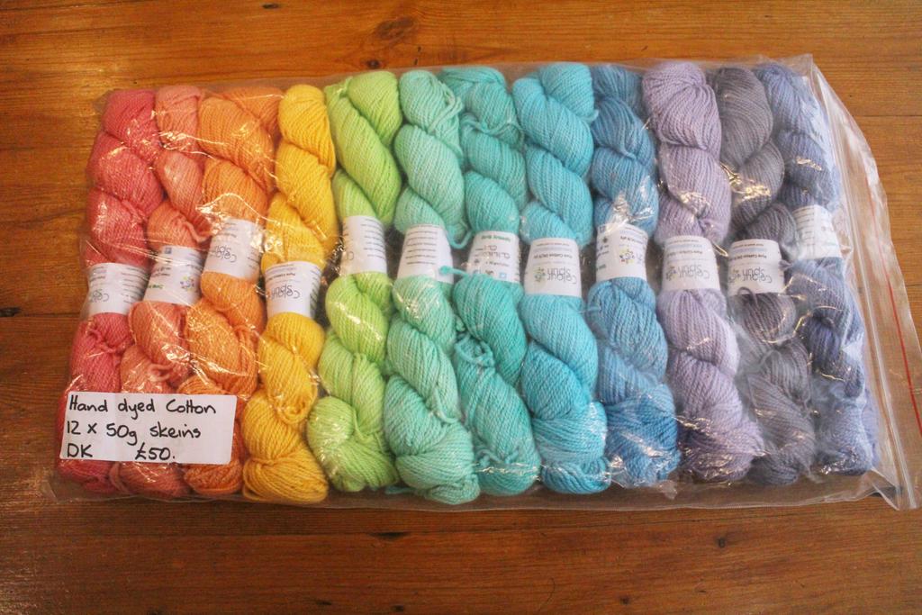 Colourful pack of 12 skeins of cotton yarn arranged in a rainbow