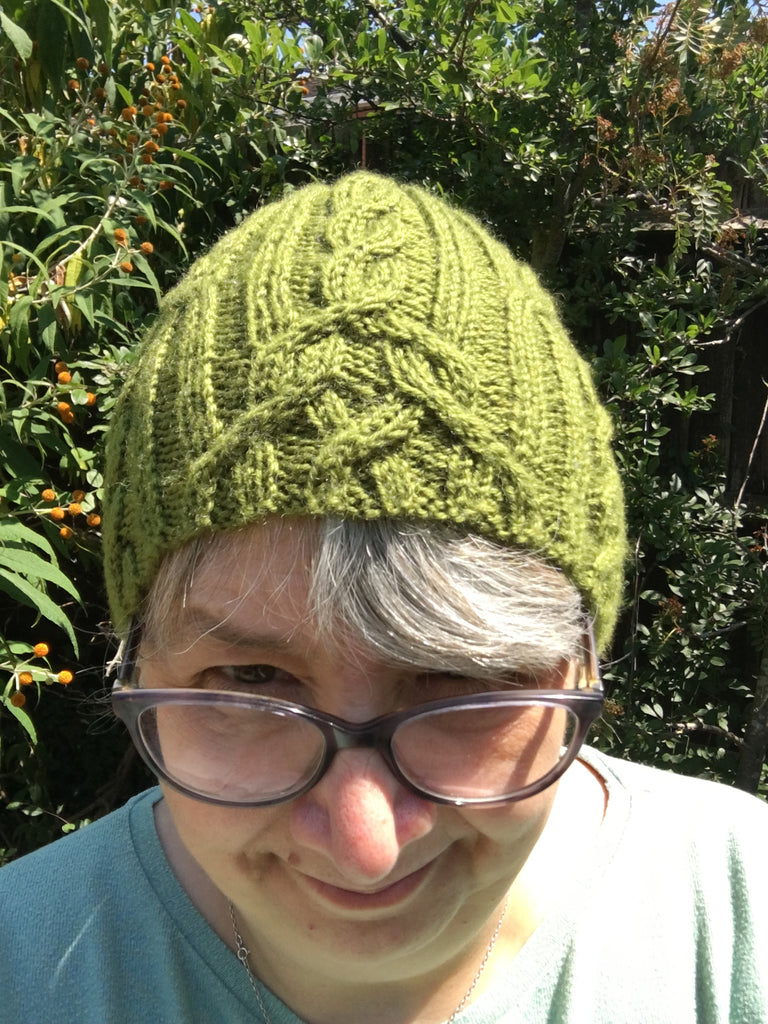 Woman wearing a green cabled hat 